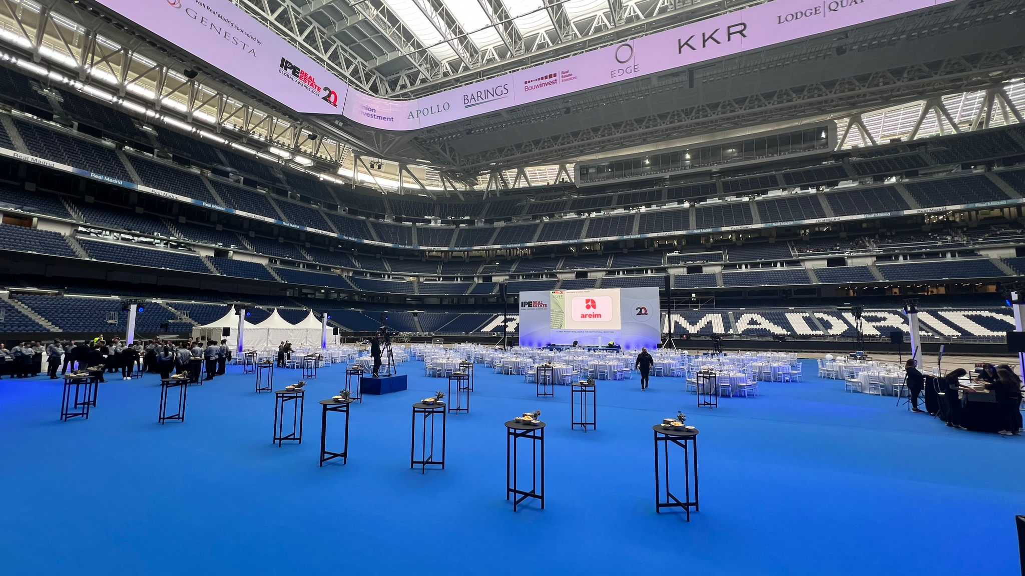 Event on the football pitch, blue floor, tables with chairs for an aperitive or dinner